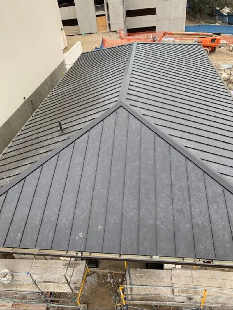 Commercial metal roof construction with crane equipment in Lake of the Woods